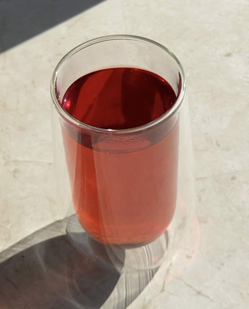 Brewed cup of The Rescue by Blissblends wellness teas, a bold herbal infusion that supports your body during period pain, stomach ache, bloating while also promoting acne-free skin.