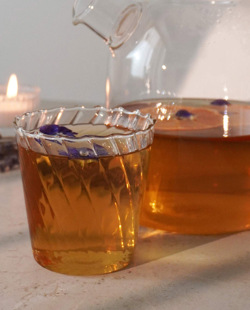 BlissBlends Sleep Serenity No.7 herbal tea being poured into a glass at night. A calming sleep ritual with organic lavender, chamomile, and passionflower for deeper sleep and nervous system relief.